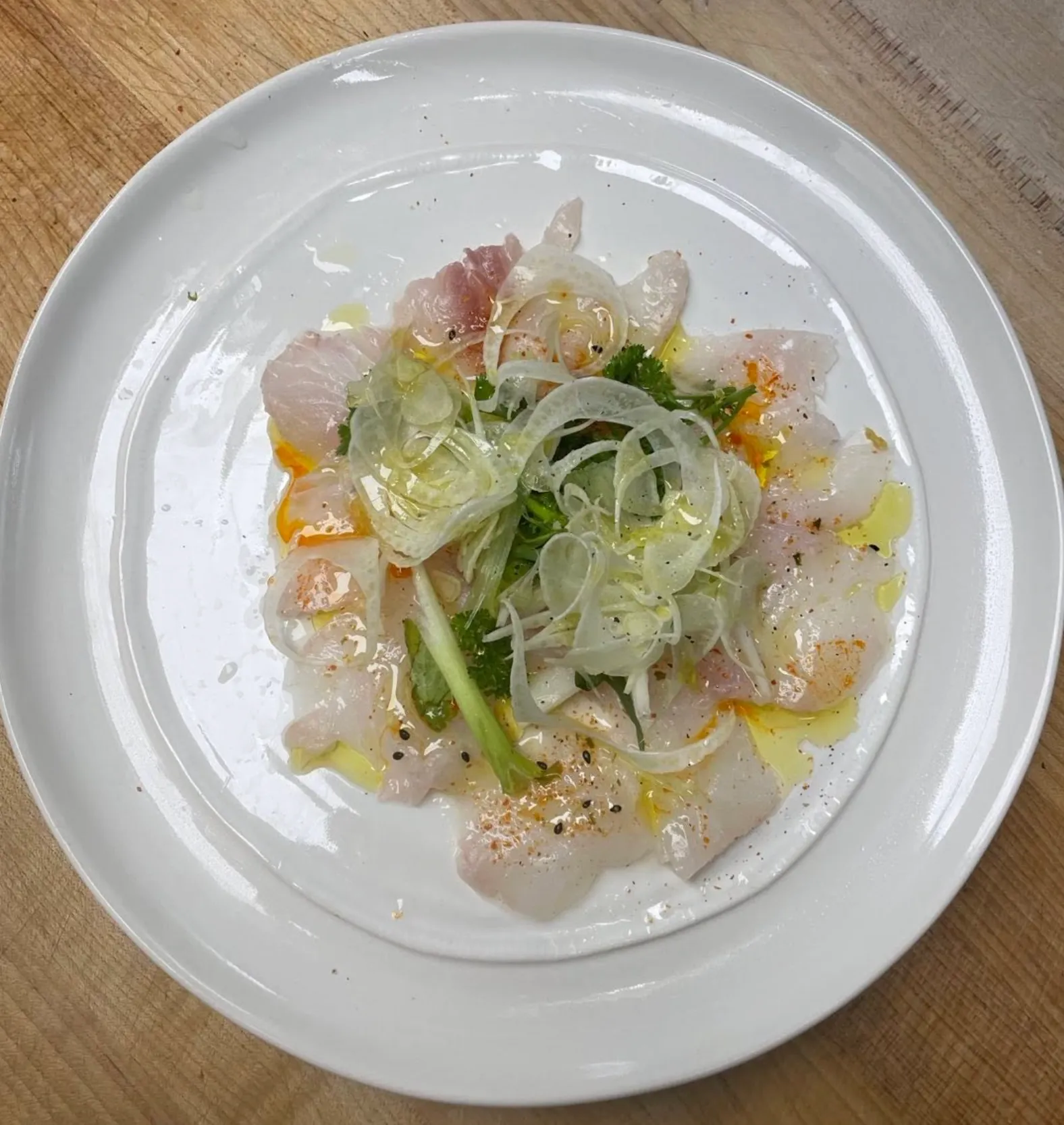 Fish carpaccio on white plate
